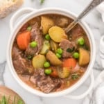 Crockpot beef stew in a small white bowl.