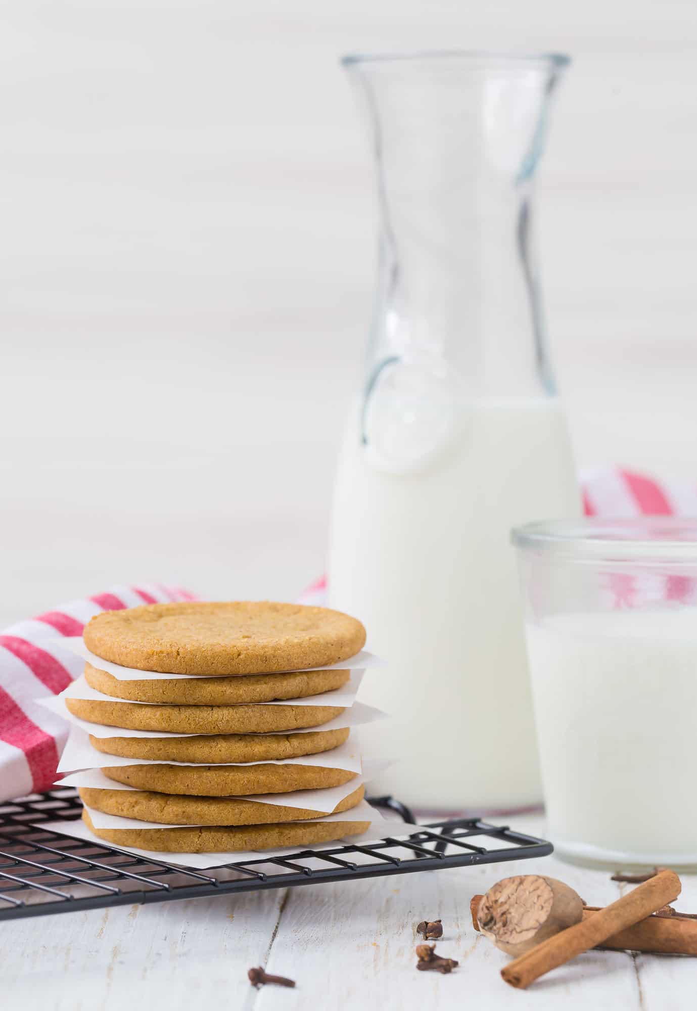 Stack of windmill cookies in front of milk.