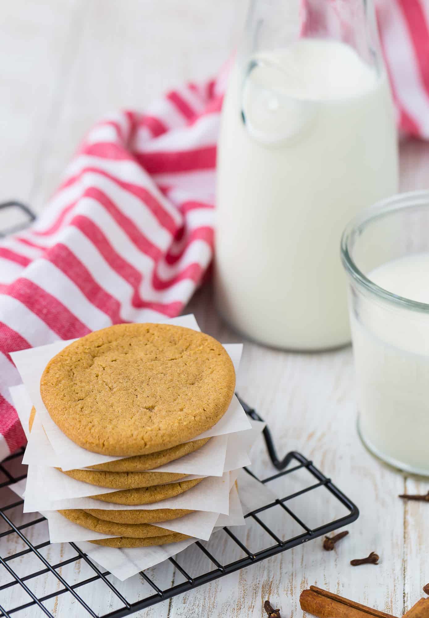 Windmill cookies in front of milk and linen.