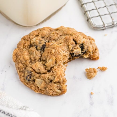 Oatmeal raisin cookie with a bite taken out of it.