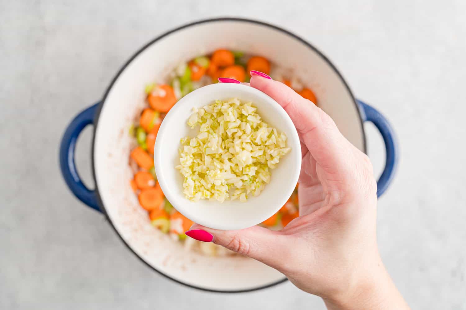 Garlic being added to pan.