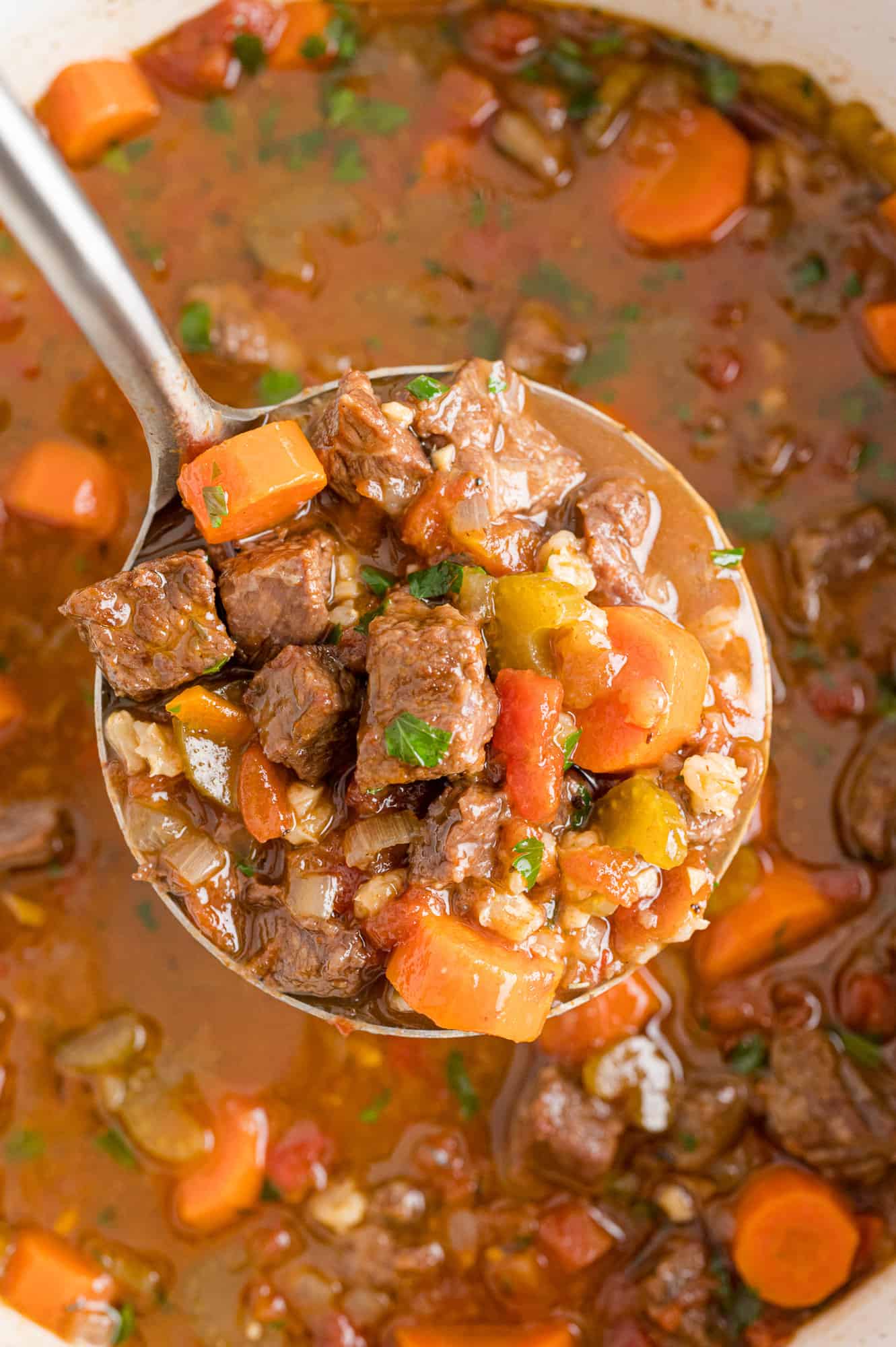 Beef barley soup on a ladle.