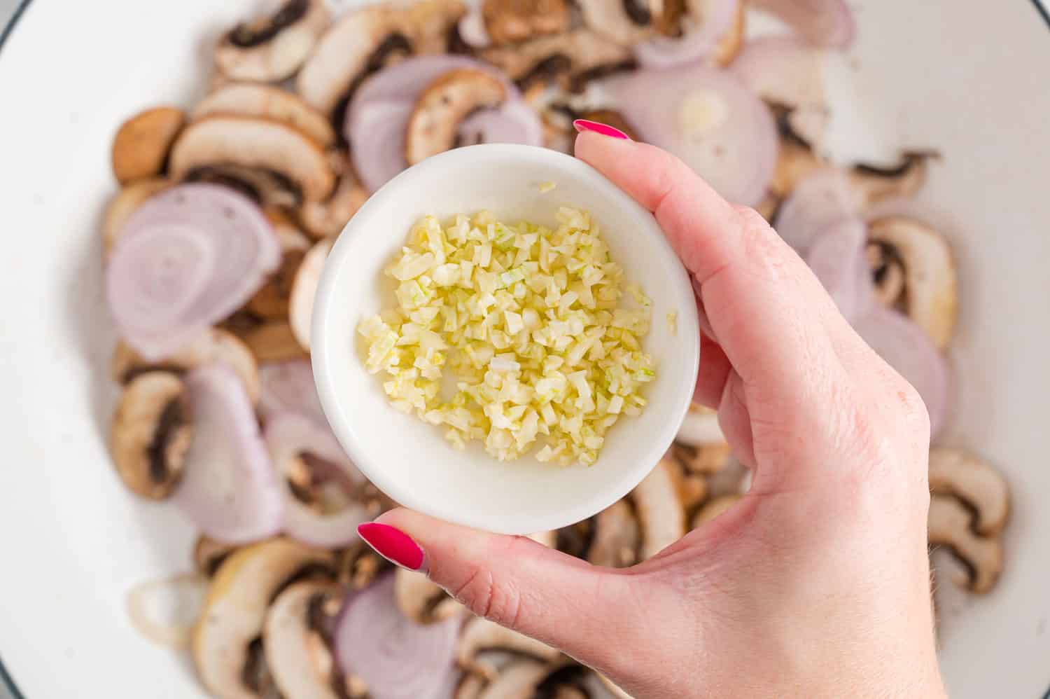 Garlic being added to pan.