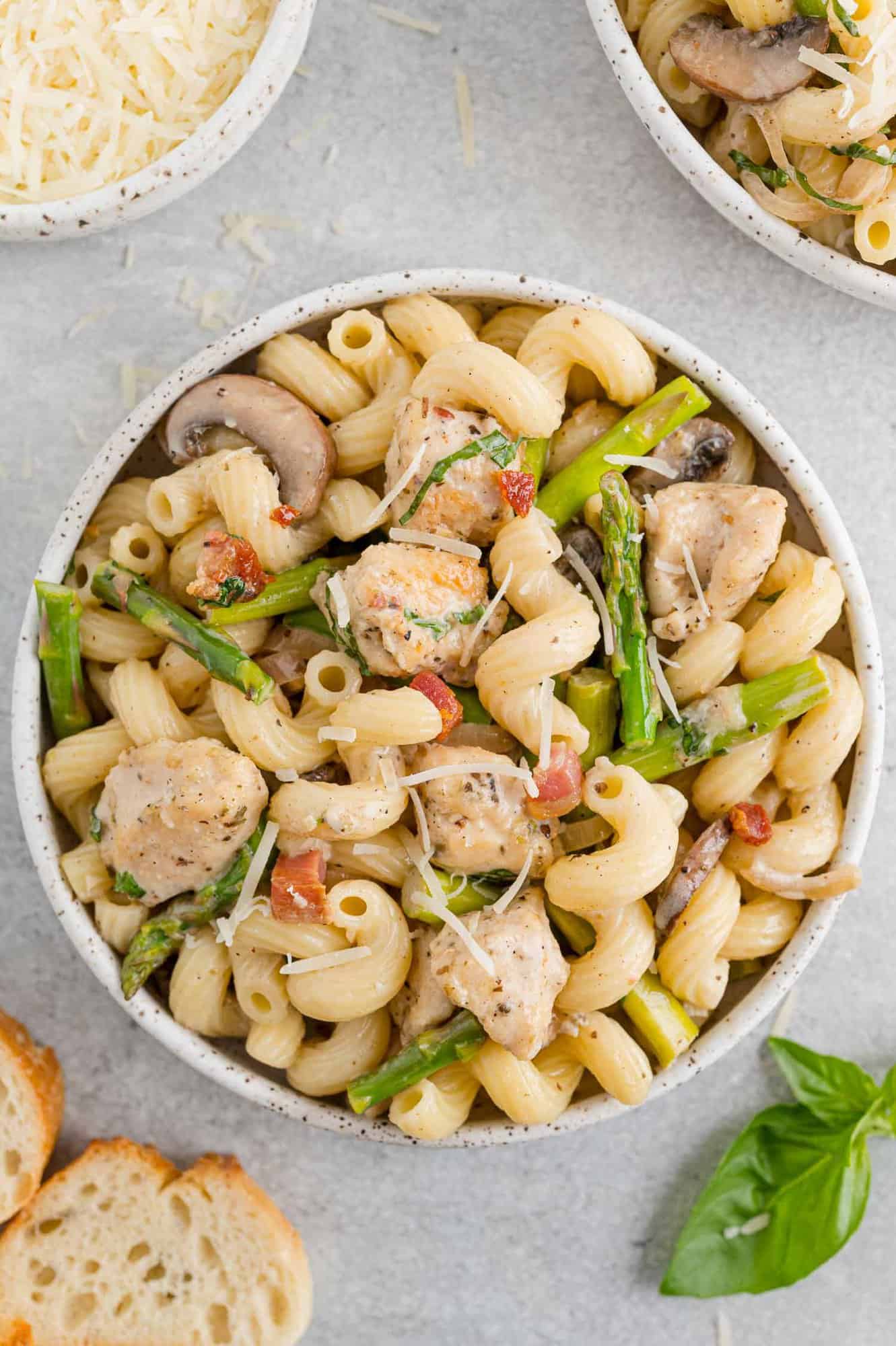 Creamy chicken pasta with chicken and asparagus in a bowl.