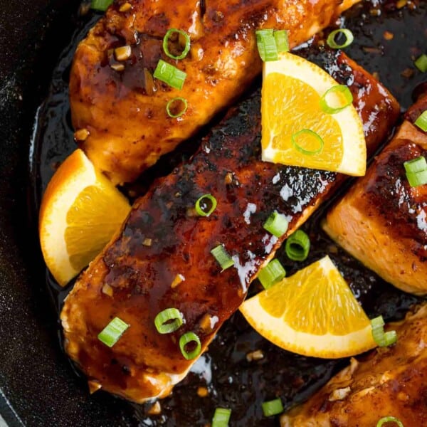 Orange glazed salmon in a frying pan.