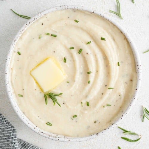 Creamy white parsnip puree garnished with rosemary.