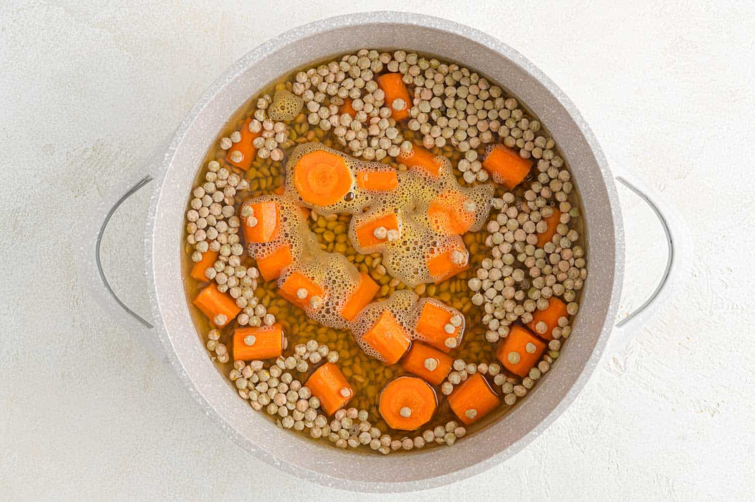 Carrots and lentils boiling.