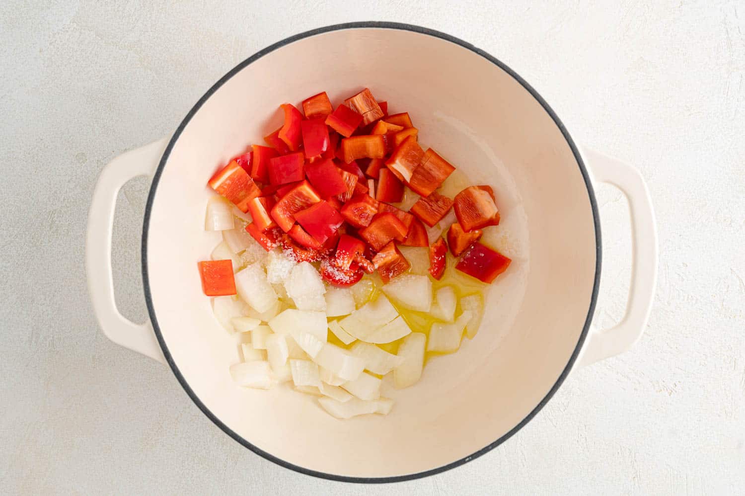 Uncooked peppers and onions in a pan.