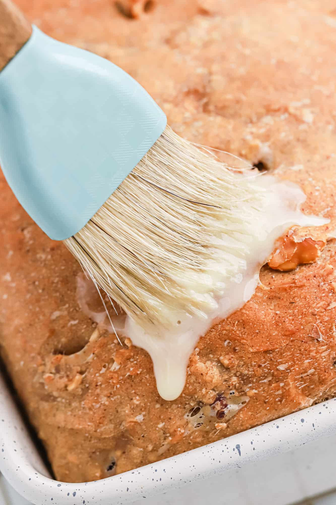 Bread being brushed with butter.