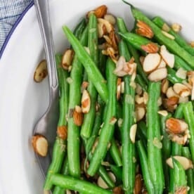 Green beans almondine on a white plate.