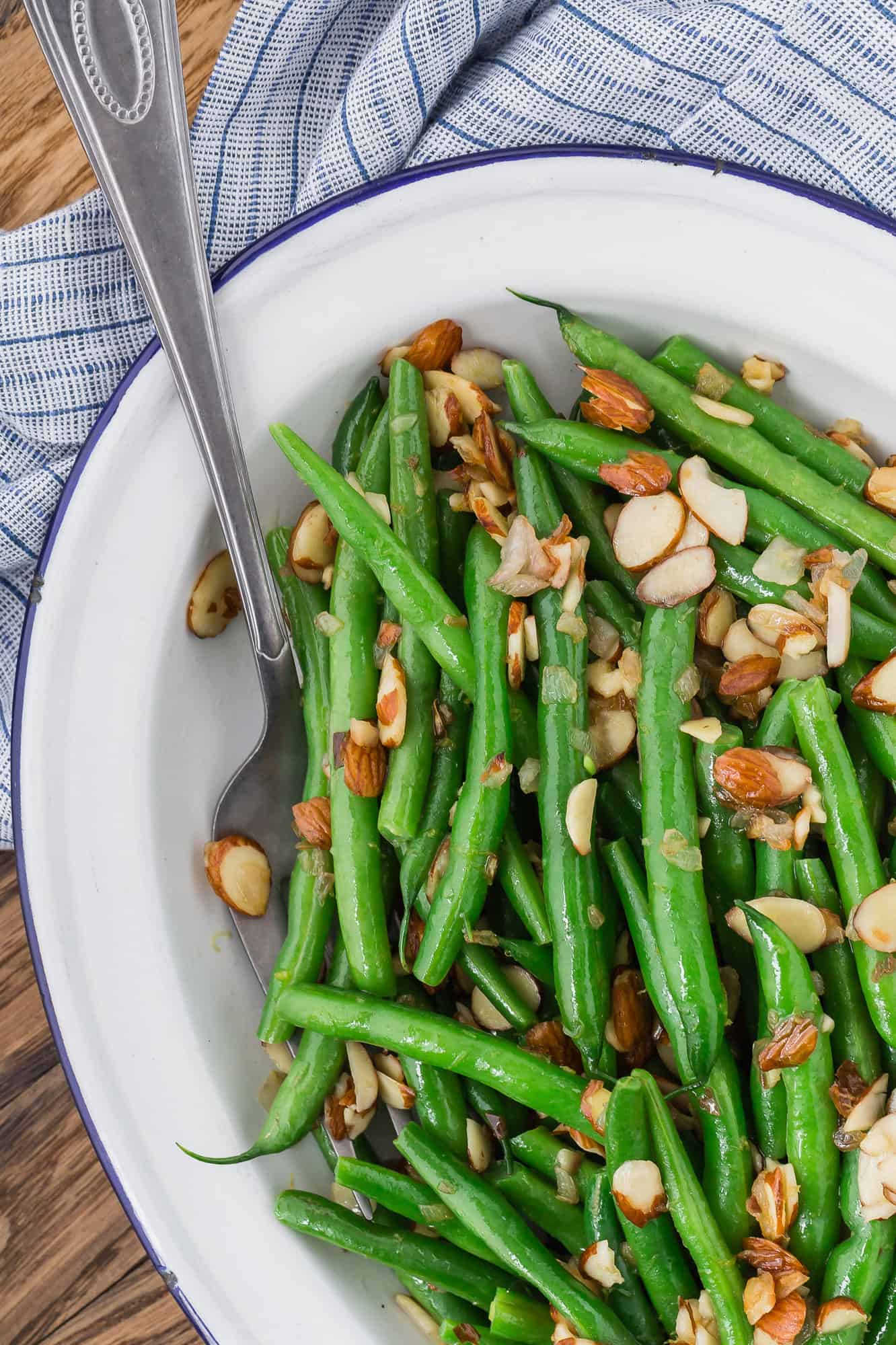Green beans almondine on a white platter.