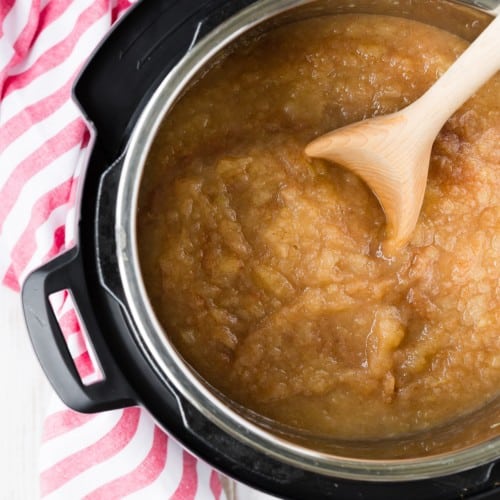Overhead view of applesauce in an Instant Pot with wooden spoon.