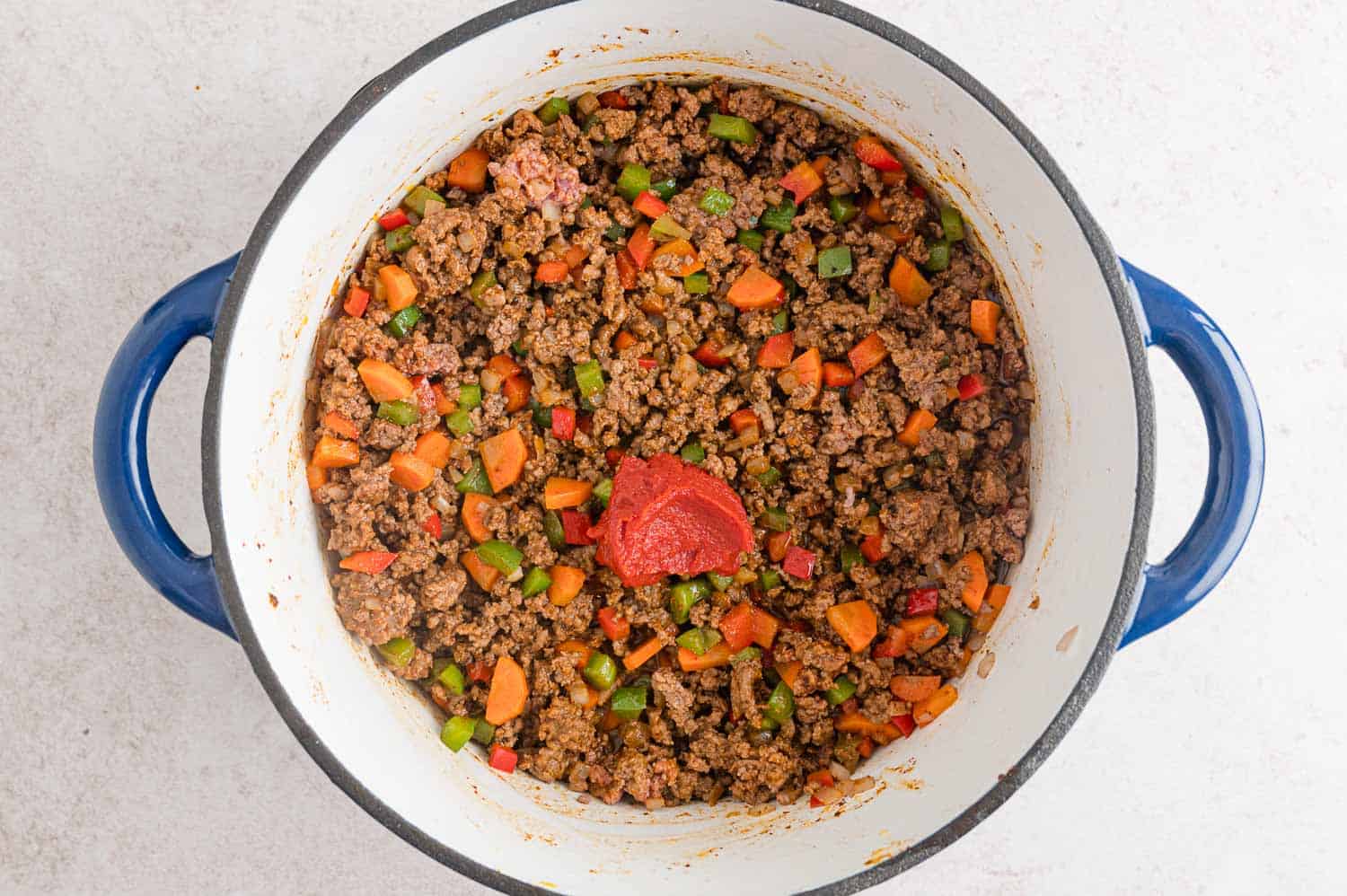 Tomato paste added to pan.