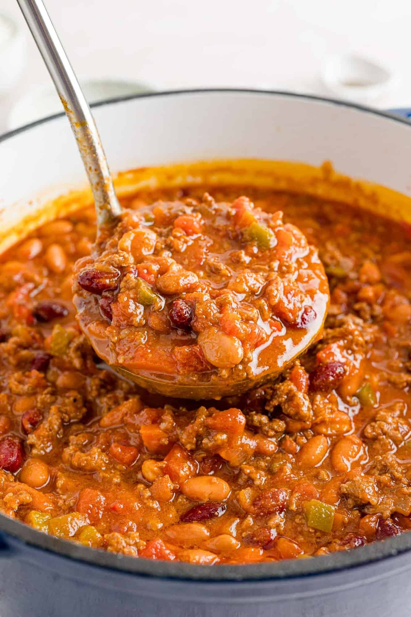 Chili being scooped out with a ladle.