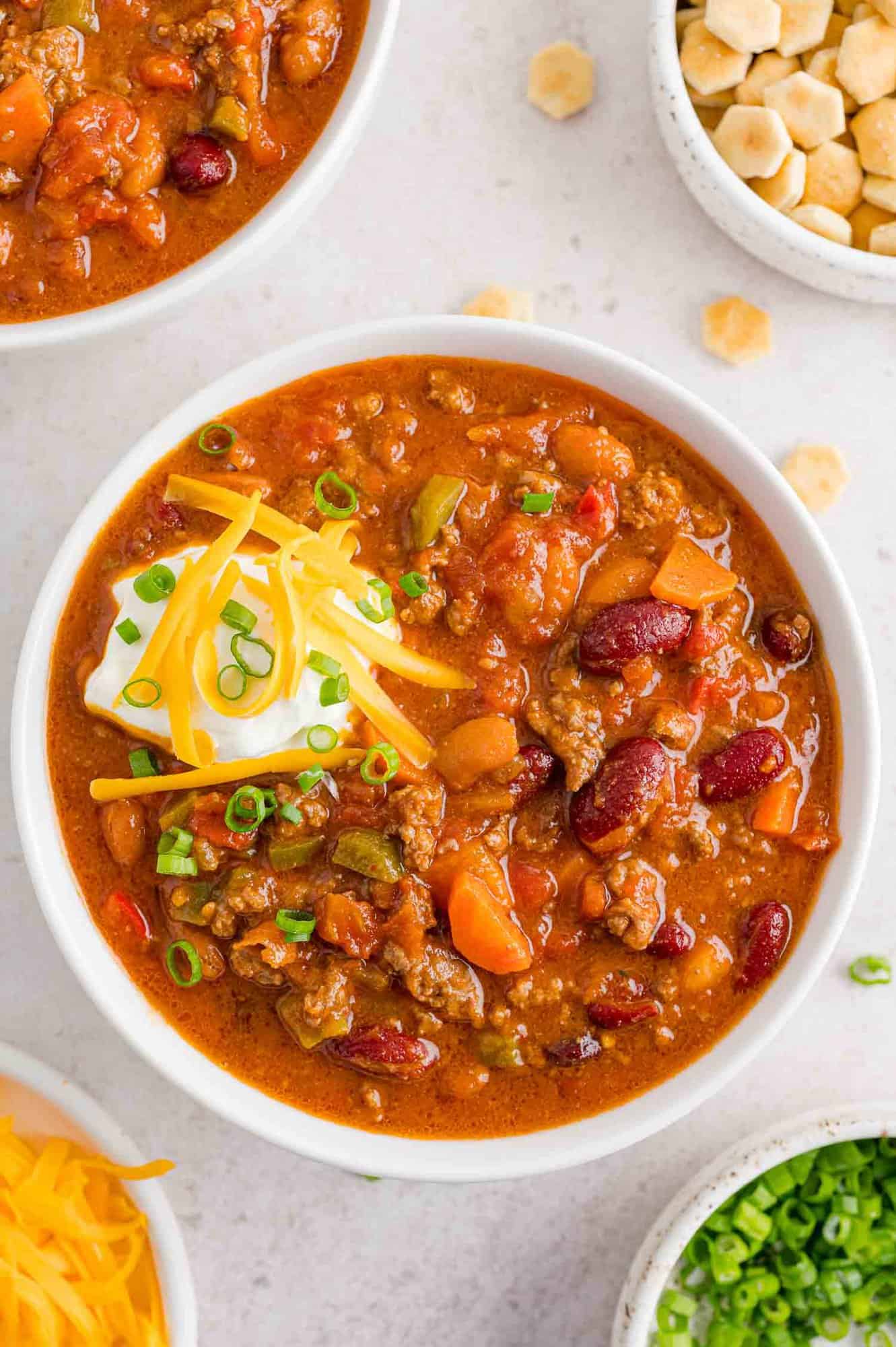 Beef chili with beans topped with cheese and sour cream.
