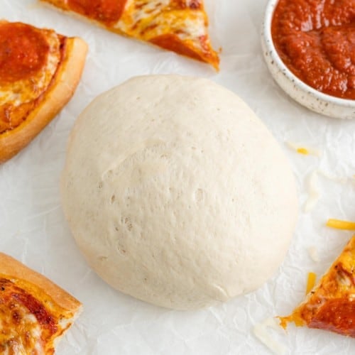 Pizza dough, surrounded by pizza.