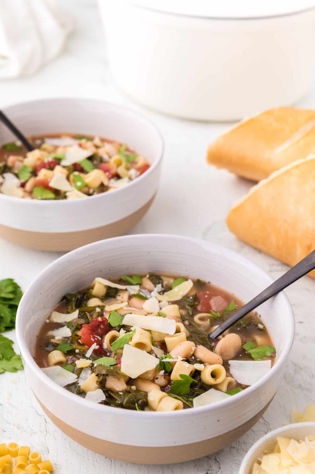 Two bowls of pasta e fagioli, bread also.