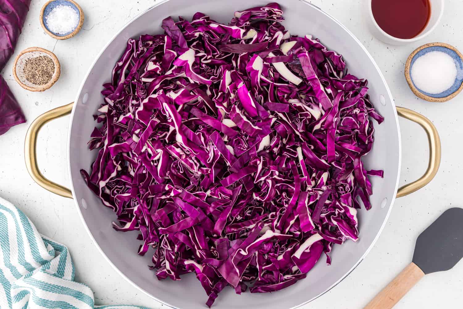 Uncooked sliced red cabbage in a skillet.