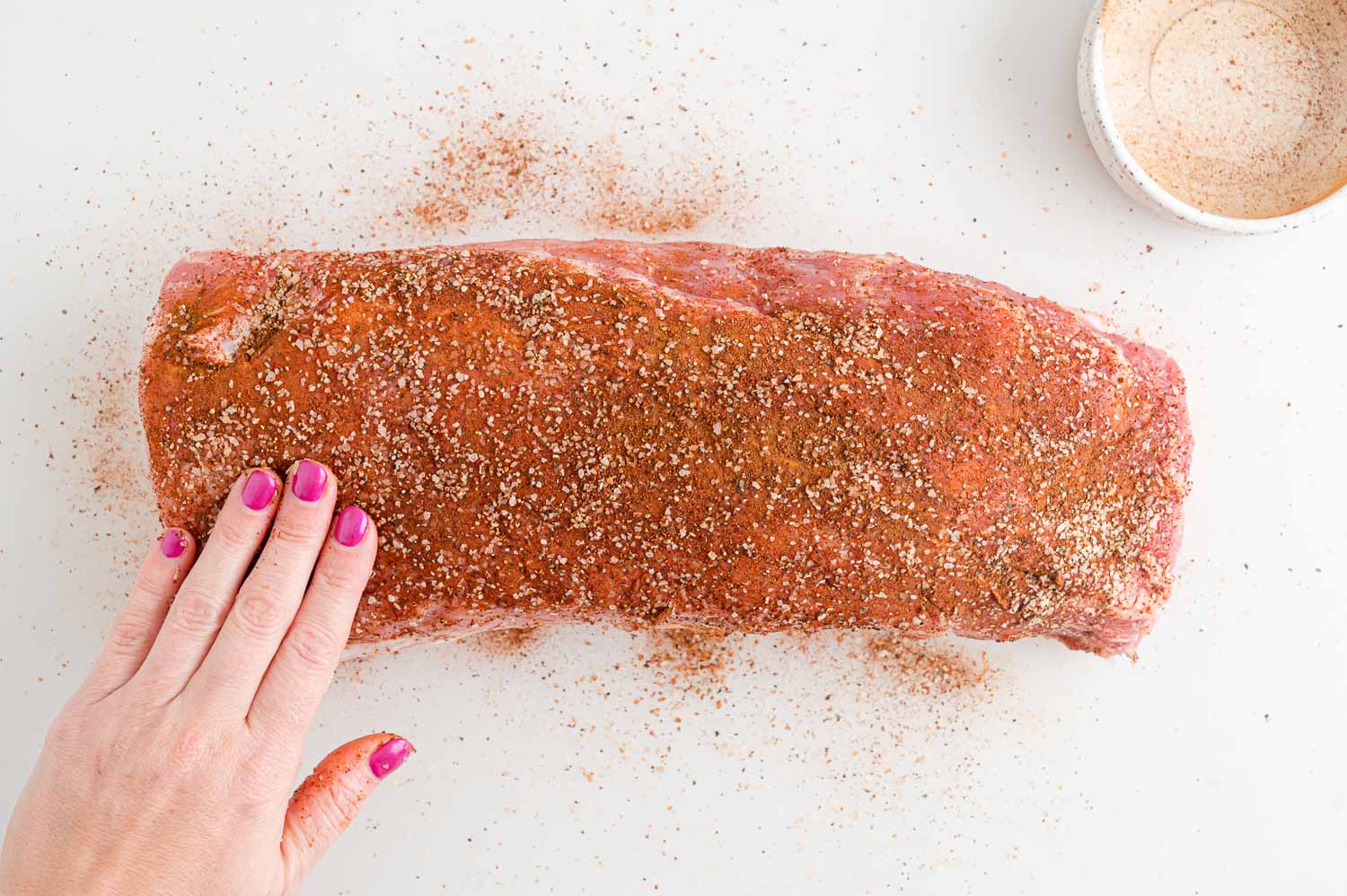 Dry rub being added to pork