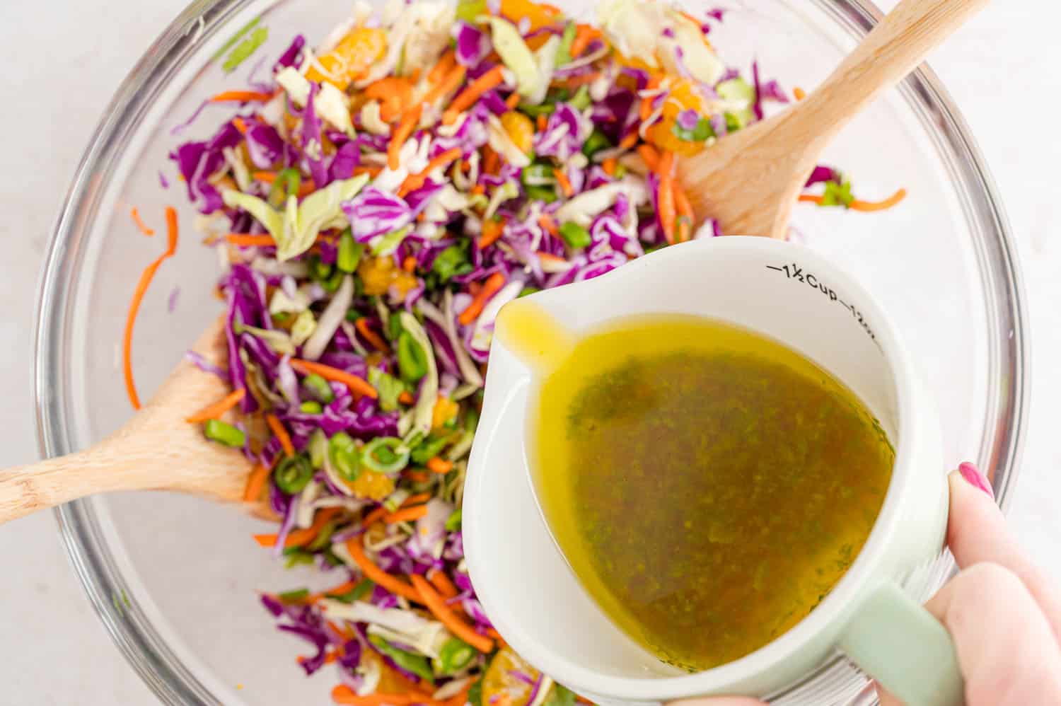 Dressing being poured onto salad.