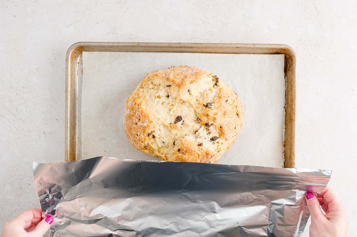 Bread being covered with foil partway through baking.