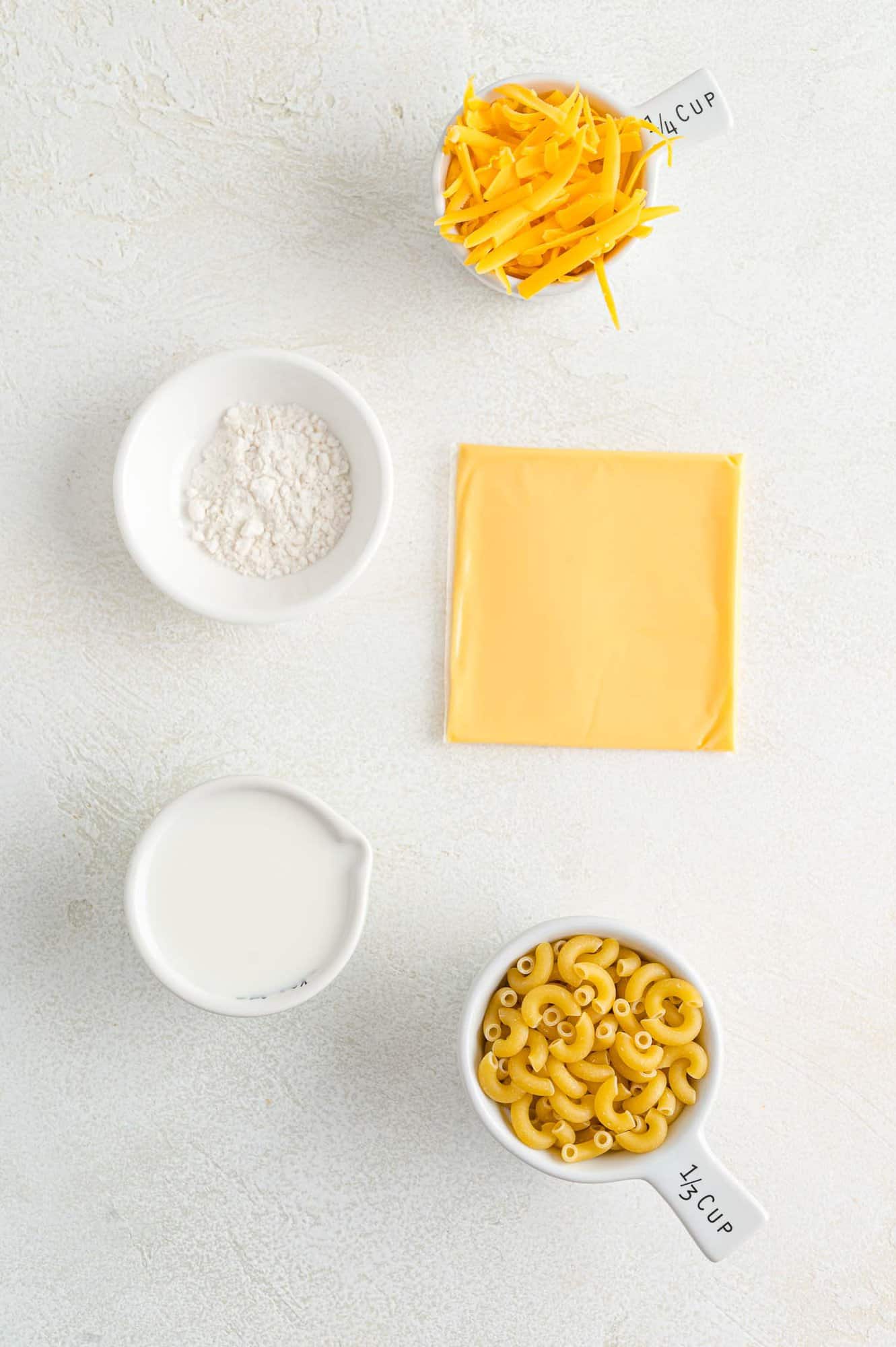 Ingredients needed for recipe, including cheese and macaroni pasta.