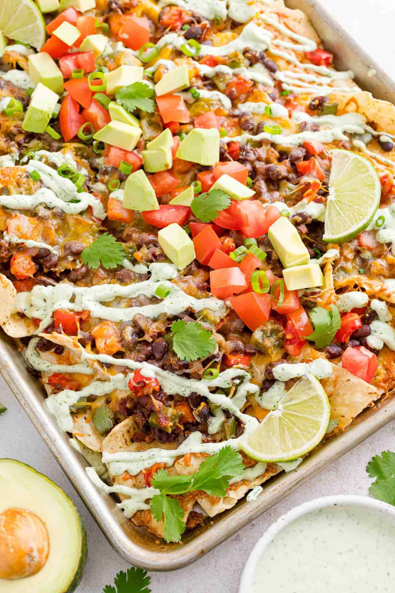 Nachos and toppings on a sheet pan.