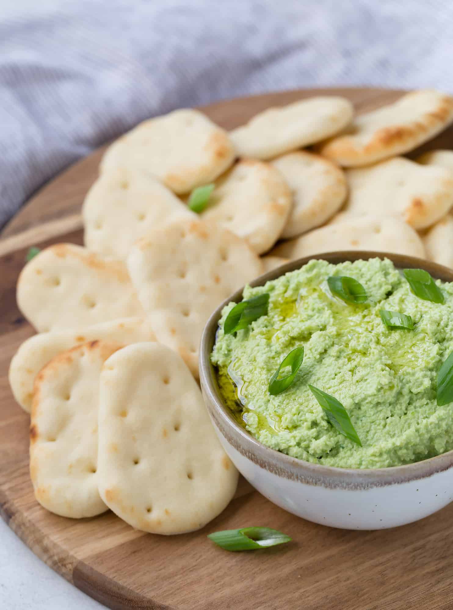 Bright green edamame dip with small pitas.