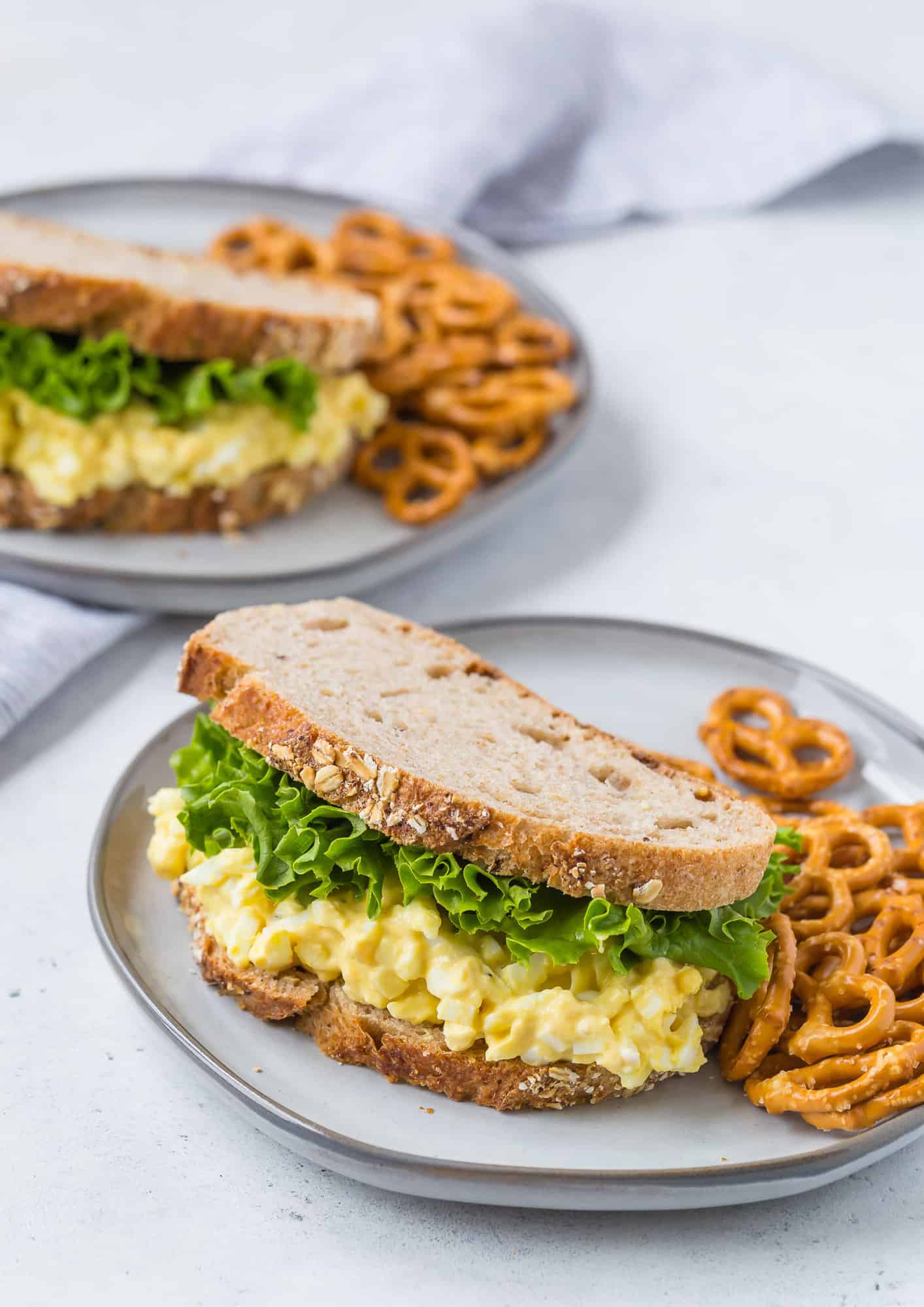 Egg salad on whole grain bread with leaf lettuce.