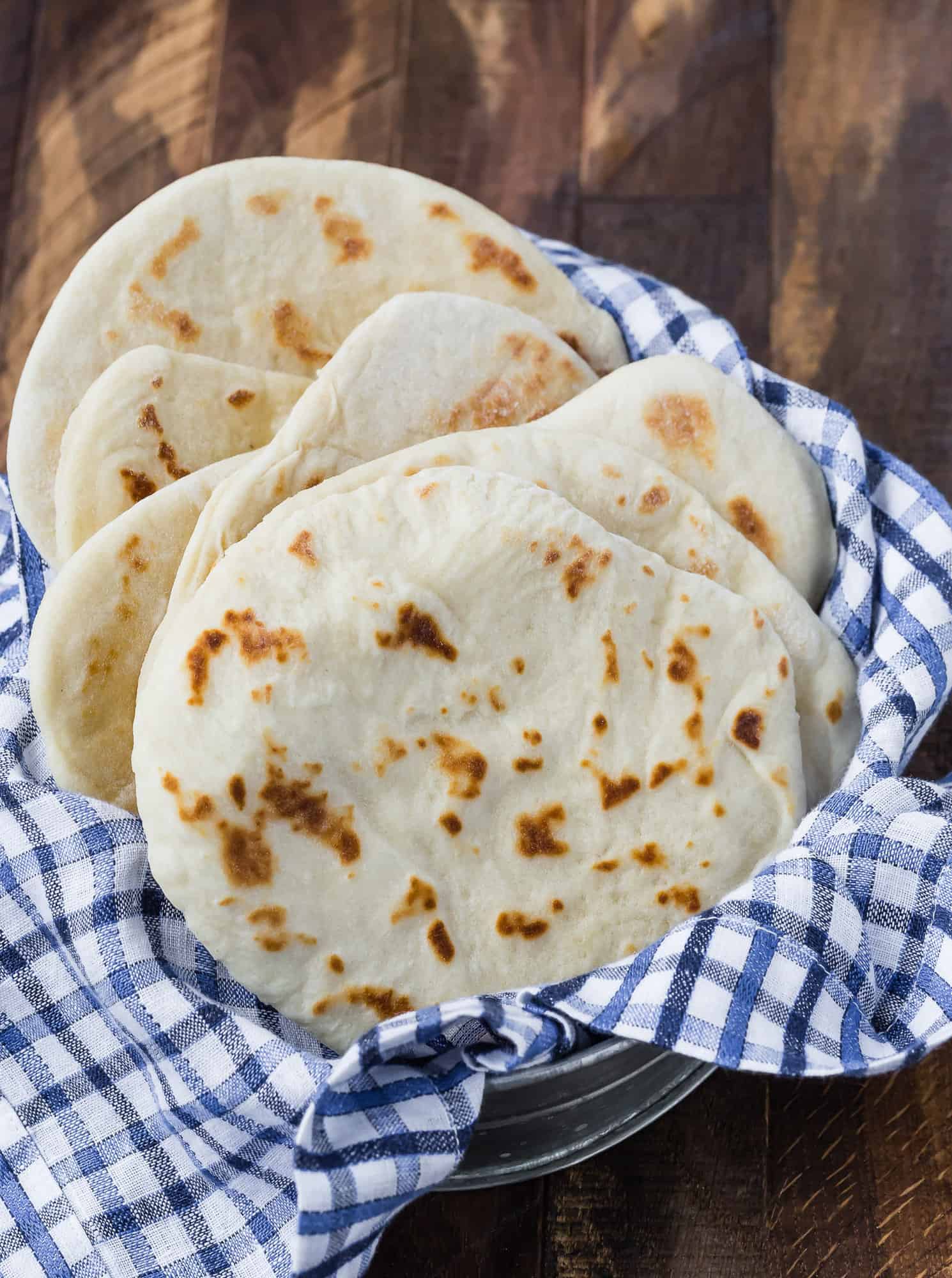 Flatbread in a basket with a blue and white linen.