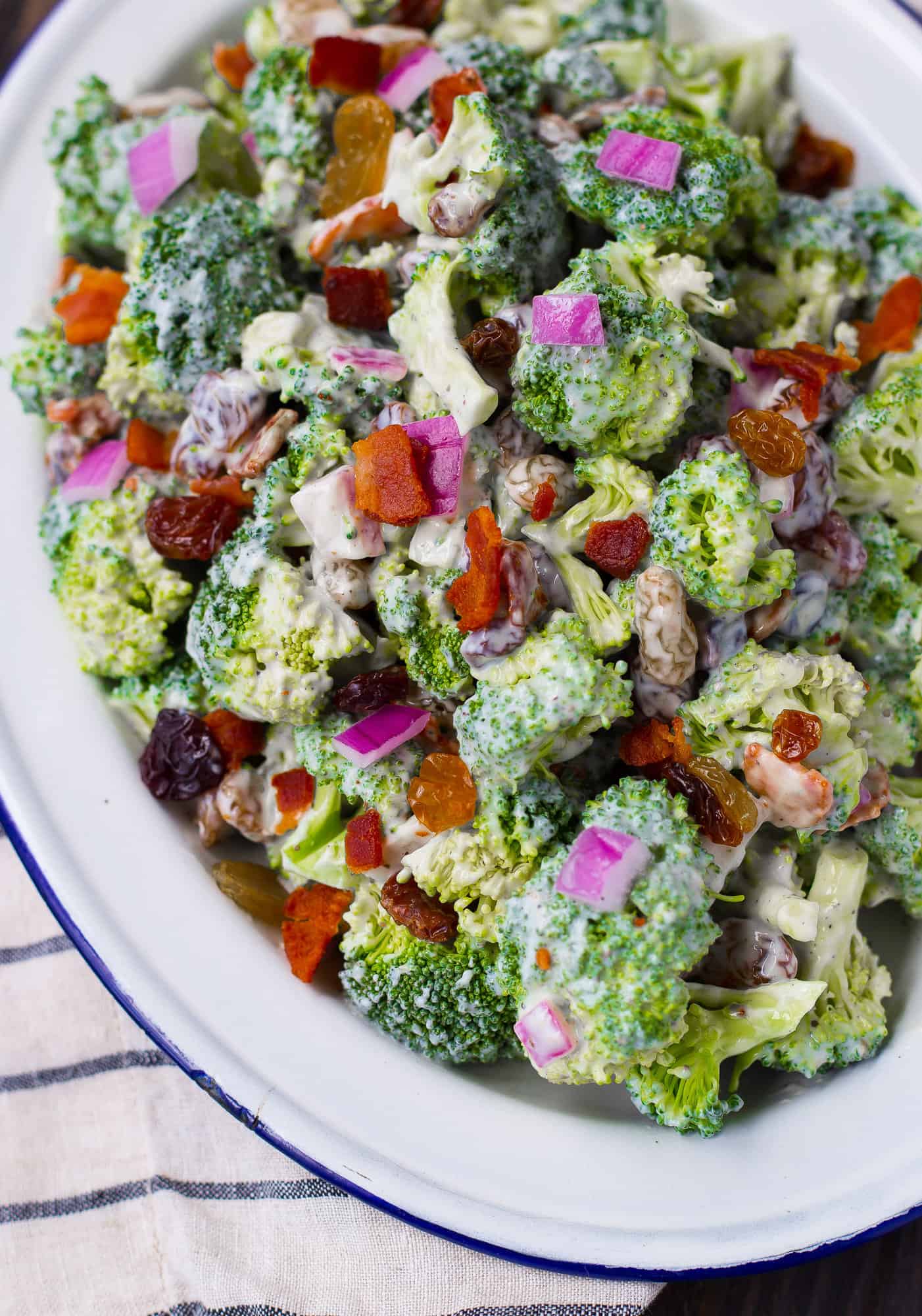 Broccoli salad on a blue and white plate.