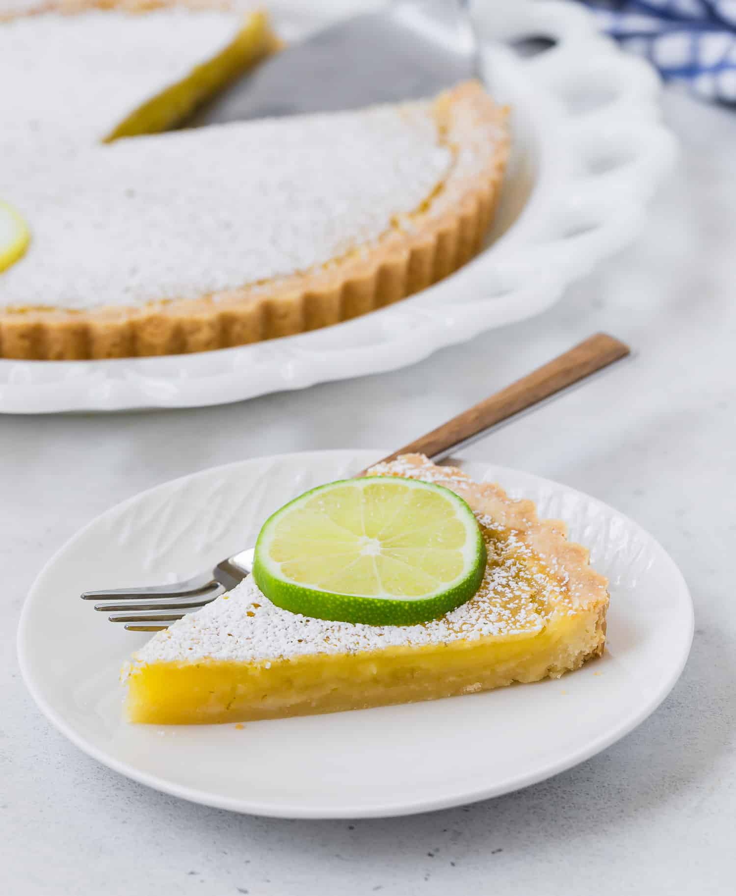 Slice of tart garnished with lime slice.