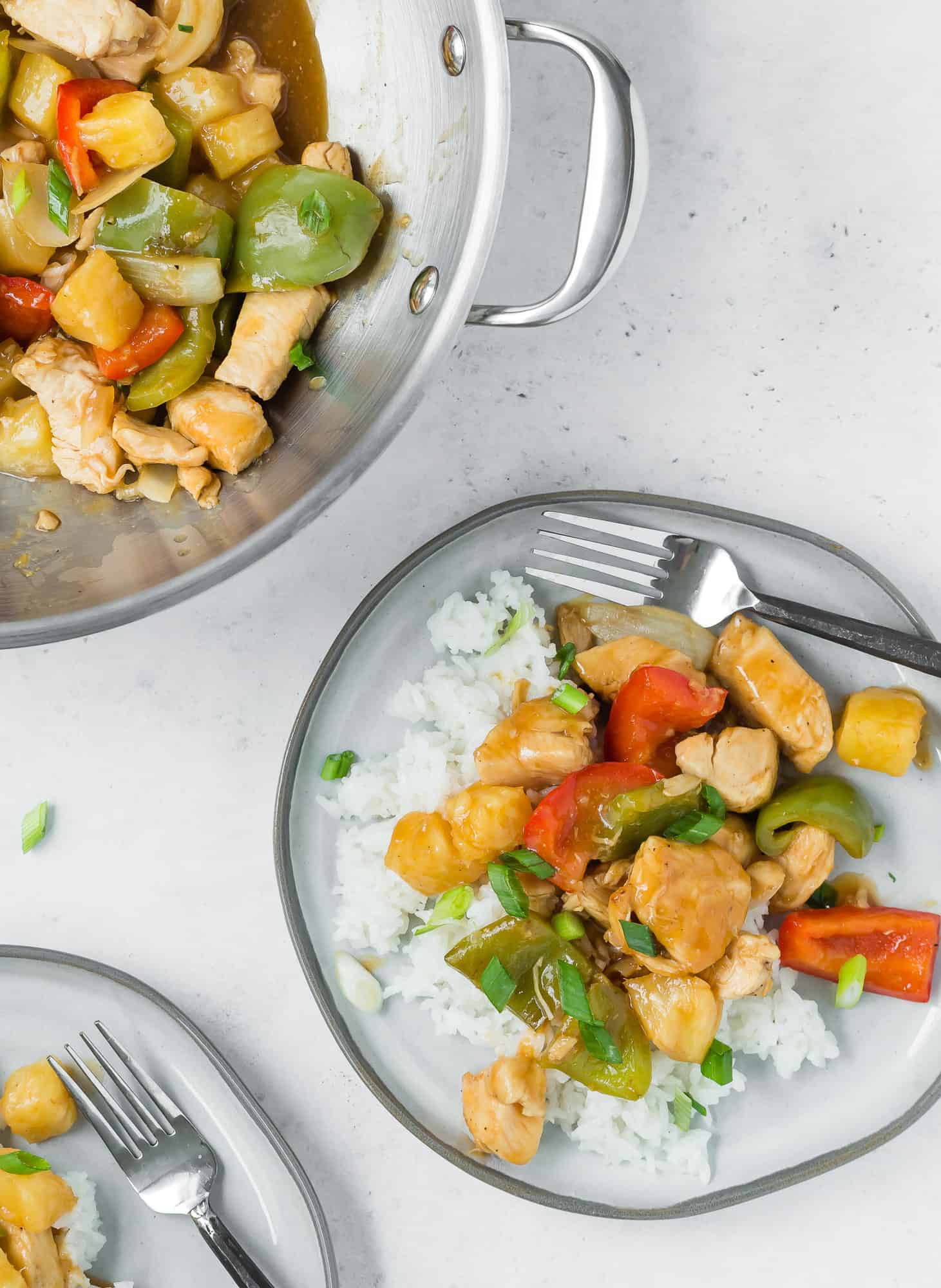 Two plates of sweet and sour chicken on rice.