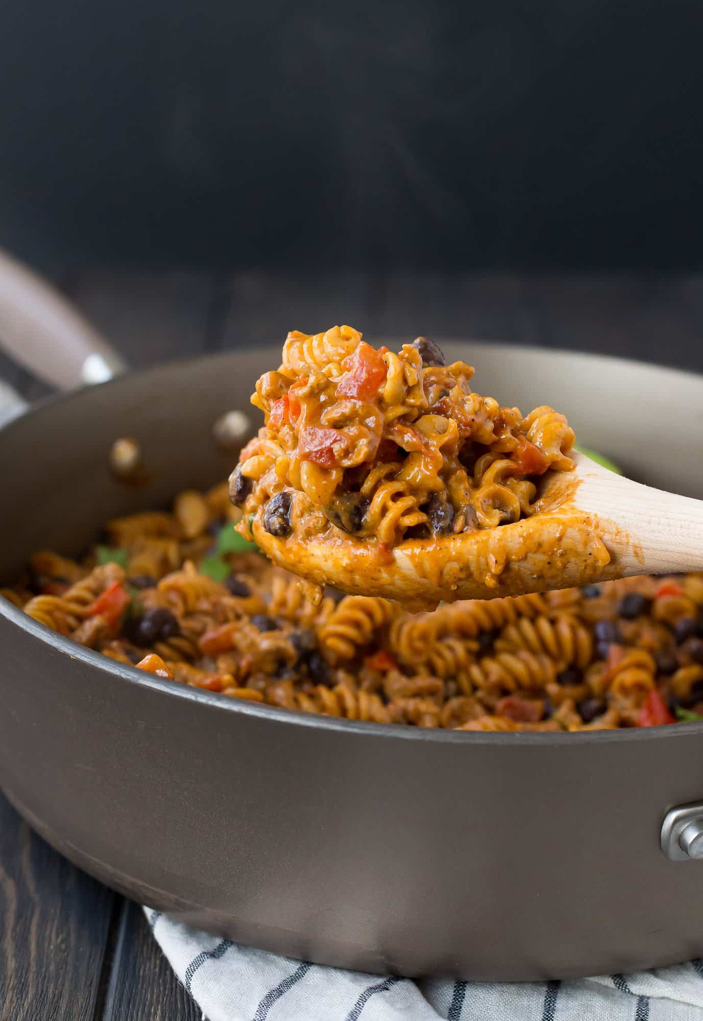 Pasta being scooped out of pan.