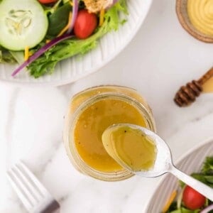 Honey mustard vinaigrette with a spoon.