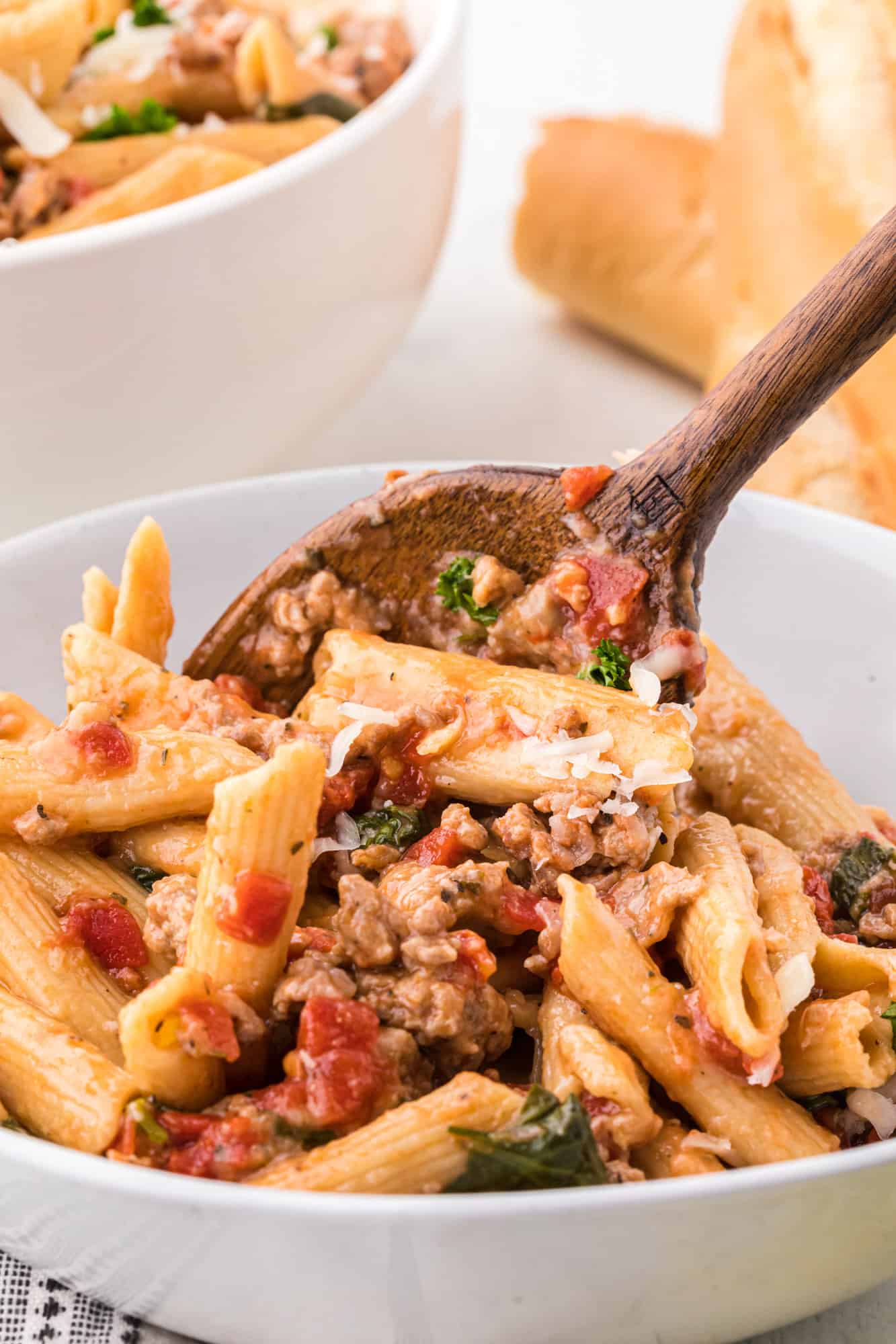 Pasta being scooped into a bowl.