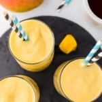 Overhead view of three mango smoothies.