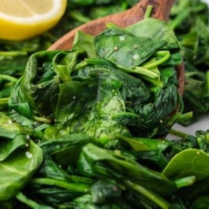 Sautéed spinach and a wooden spoon.