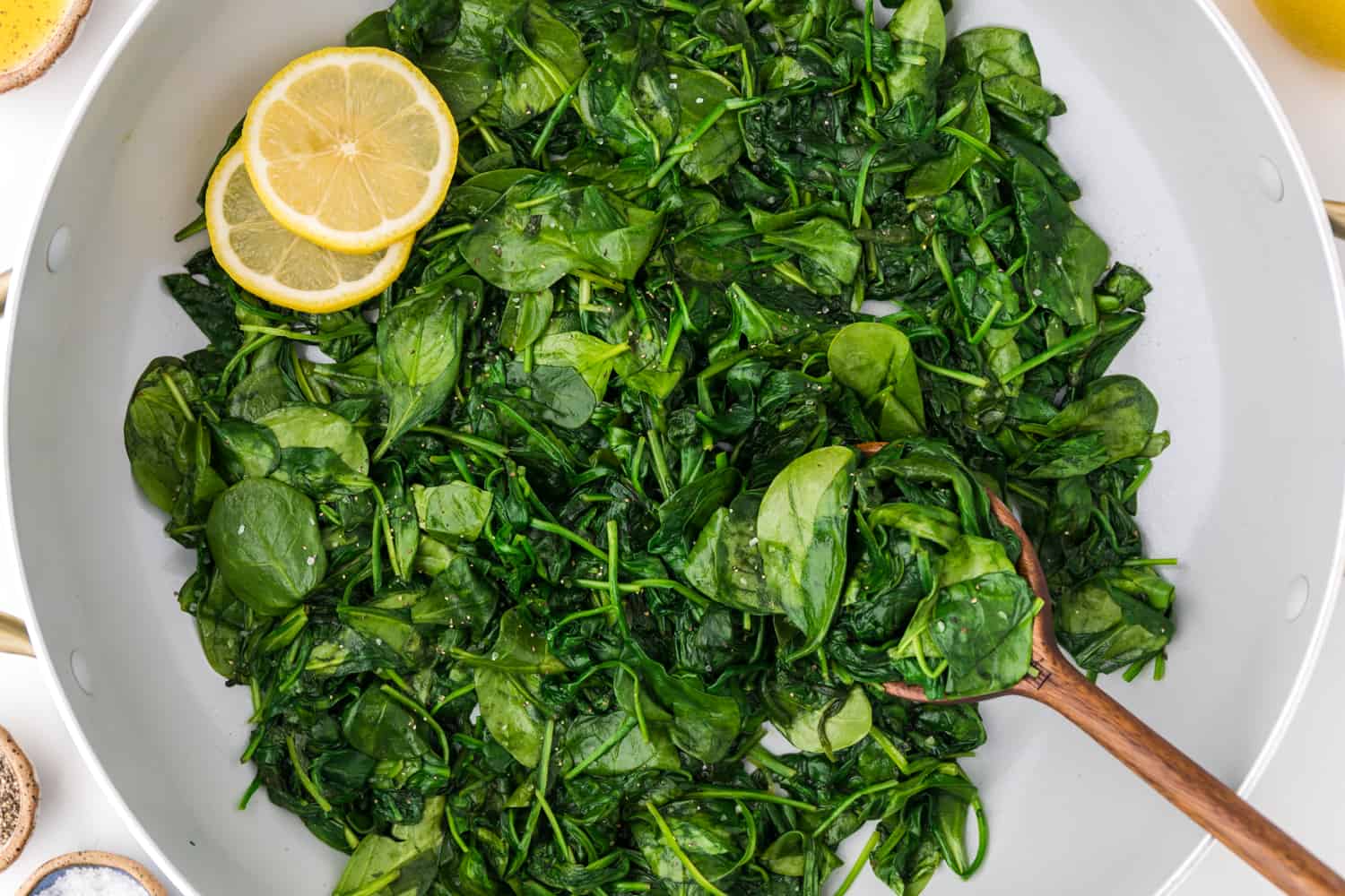 Cooked spinach with lemon slices.