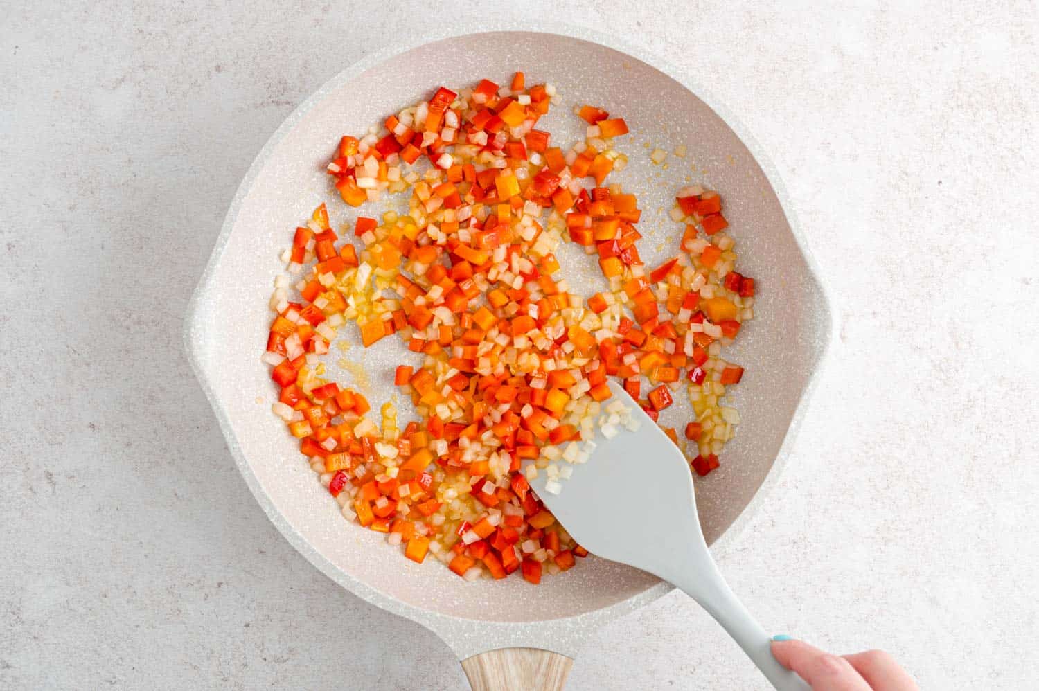 Peppers and onions sautéed in a pan.