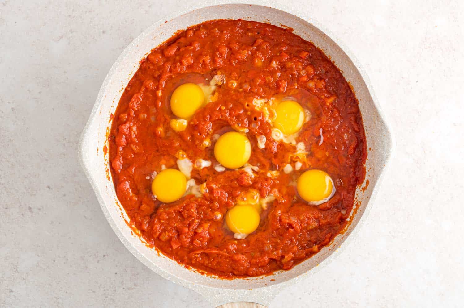 Uncooked eggs added to tomato mixture.