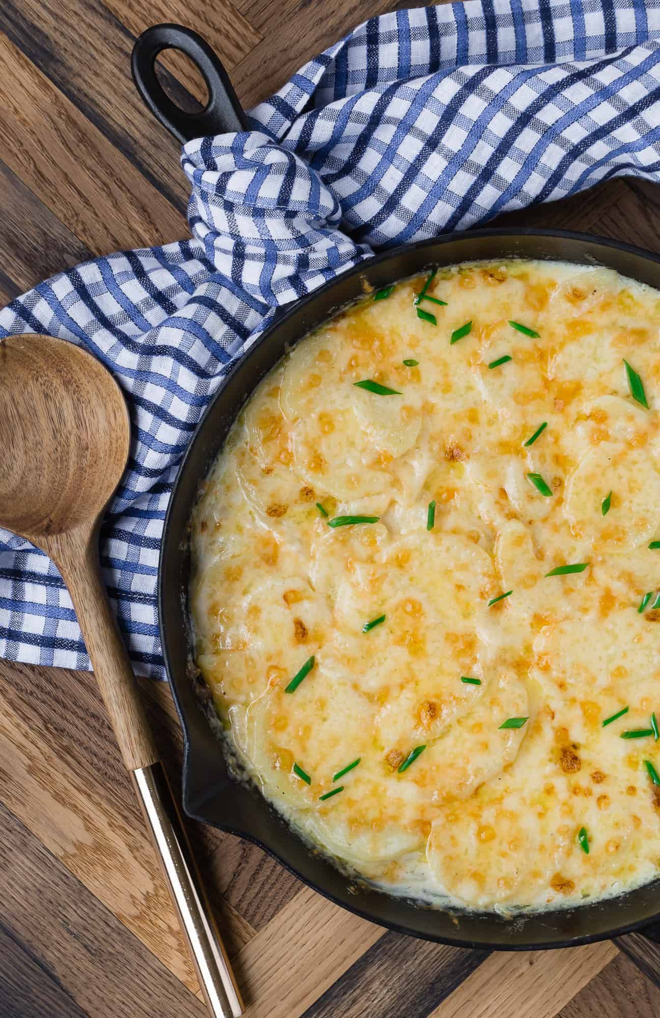 Cheesy scalloped potatoes in a skillet.