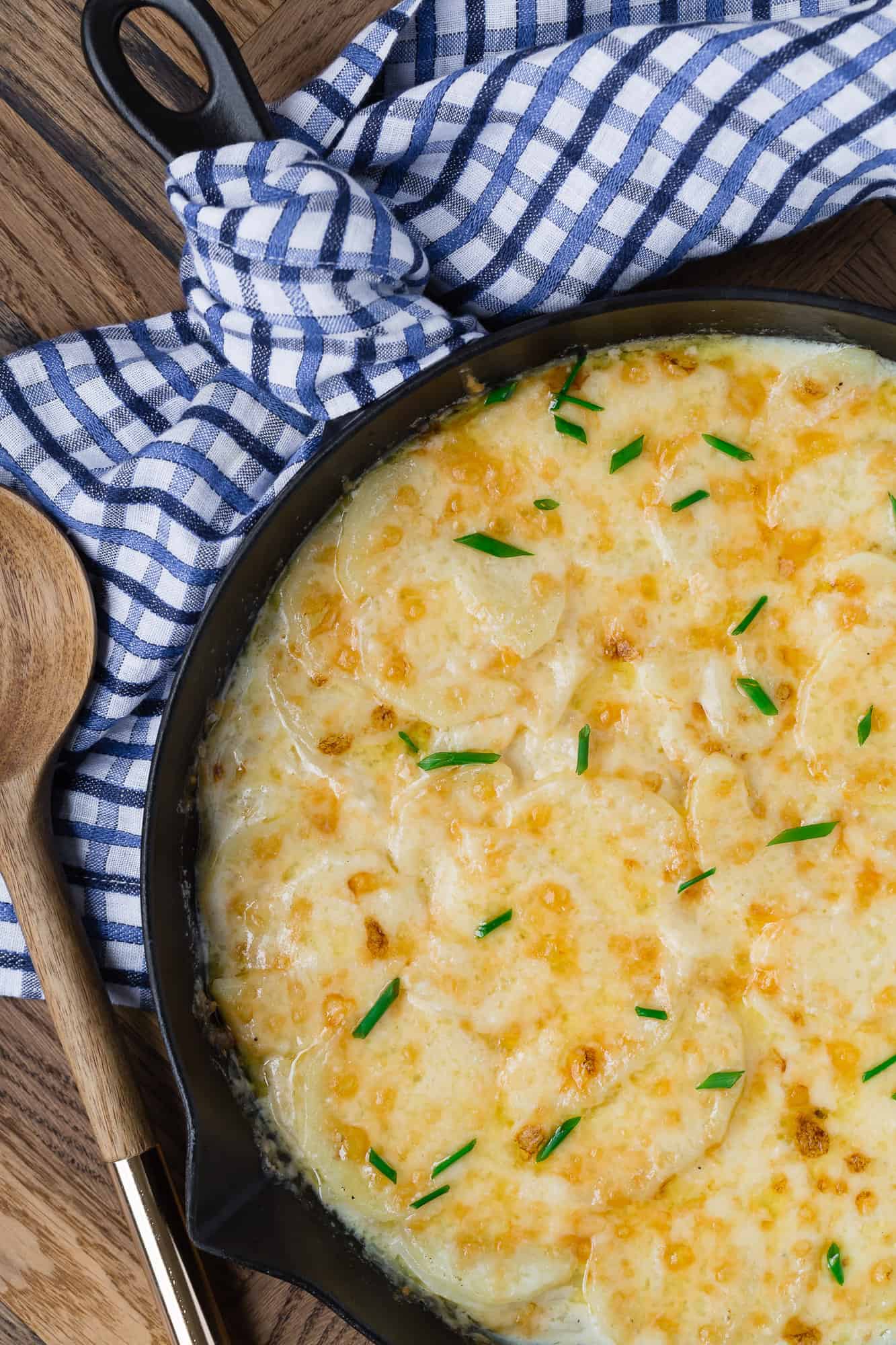 Scalloped potatoes in black cast iron skillet.