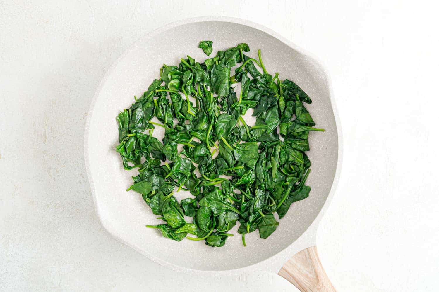 Wilted spinach in a frying pan.
