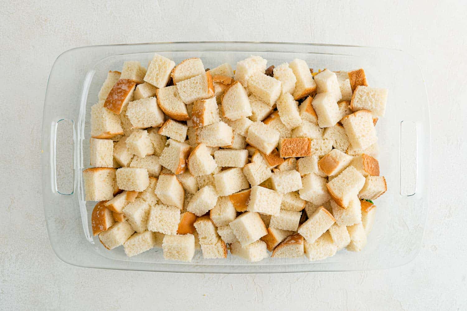 Bread cubes added to casserole dish.