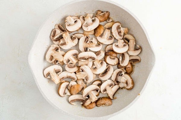 Sliced mushrooms in a skillet.