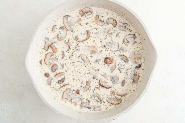 This creamy chicken marsala recipe is a fun spin on an Italian favorite! Made with tender chicken and mushrooms cooked a rich marsala sauce. Creamy marsala sauce with mushrooms in a skillet.