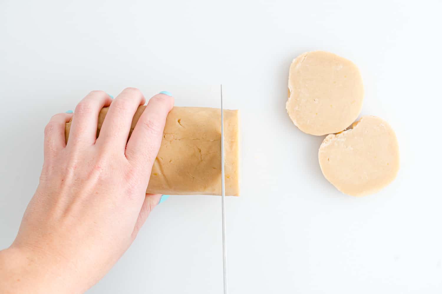 Roll of cookie dough being cut.