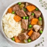 Slow cooker beef marsala stew in a white bowl with potatoes.