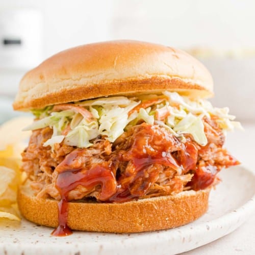 Slow cooker pulled pork on a bun with coleslaw.